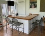 Solid hardwood bar top on a painted wood bar wall.