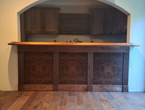 Home bar built with Walnut Bar Rails, Radius Corners & Fluted Columns by Hardwoods Incorporated