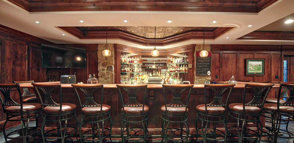 Image of a bar with bar stools in front.